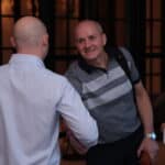 Consultants networking and smiling and building relationships in a consulting association and consulting mastermind.