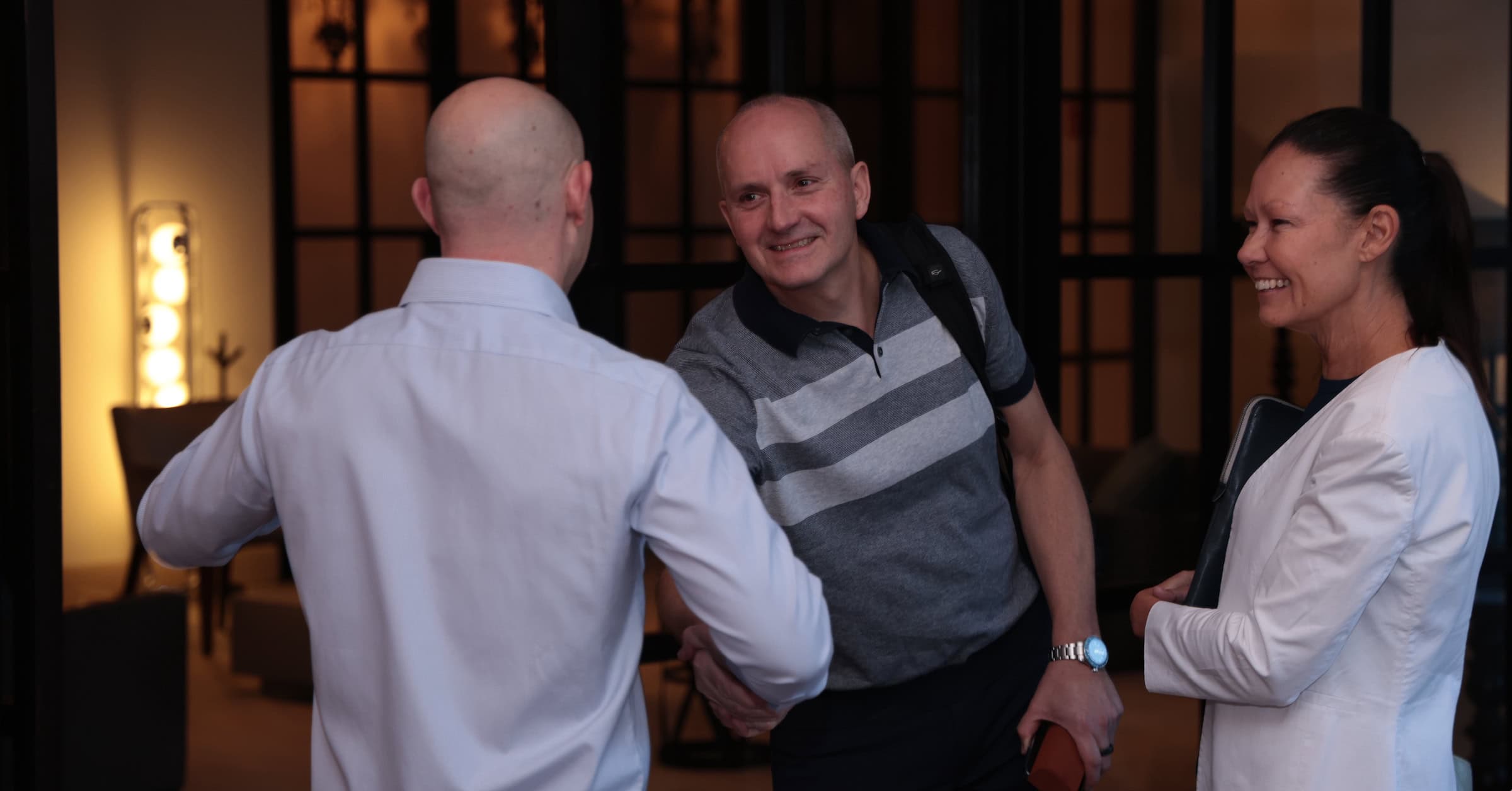 Consultants networking and smiling and building relationships in a consulting association and consulting mastermind.