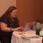 The Complete Guide to Consulting CRMs: 10 Top Tools Compared (2025) consultant sitting and looking at crm software on her laptop for her consulting business