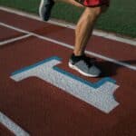 Is Being #1 In Your Field What You Really Want? A Consultant's Guide to Success on Your Terms Runner's feet mid-stride on a track lane marked with a #1 symbol, representing the pursuit of being first place.