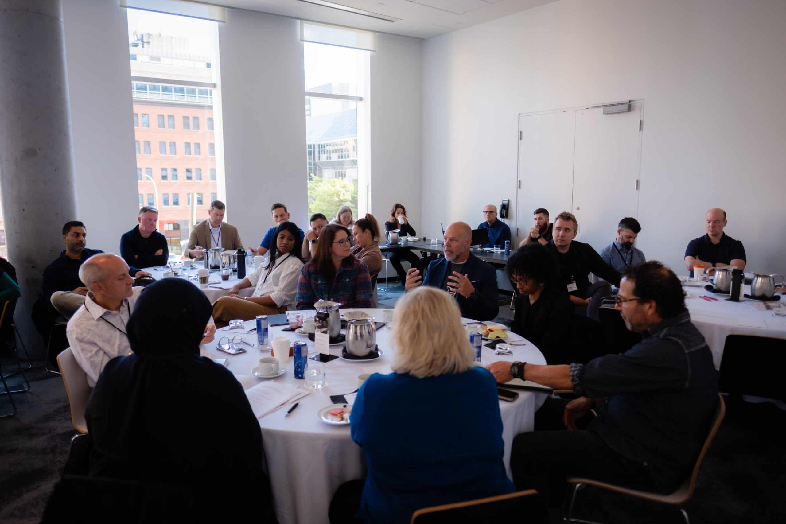 Consultants seated at round tables during a Consulting Success Inner Circle peer group session at the Montreal Mastermind Retreat.
